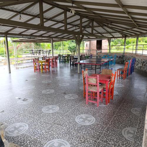 a dining room with tables and chairs in a pavilion at Hotel Campestre Los Mangos in Quimbaya