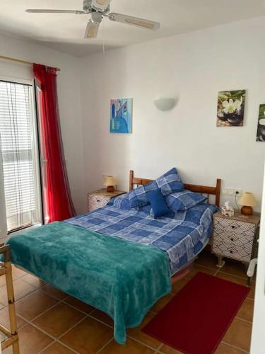 a bedroom with a bed with a blue comforter at Peaceful Apartment in the Spirit of Mojacar in Mojácar