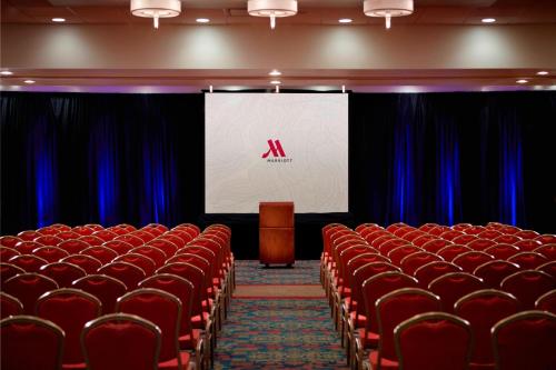 a stage with red chairs and a screen in a theater at Des Moines Marriott Downtown in Des Moines