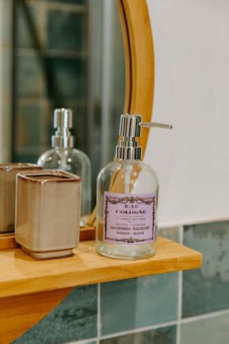 une bouteille de savon posée sur une étagère devant un miroir dans l'établissement Maison Gilberte - Avec terrasse au coeur du village, à Châteauneuf-du-Pape