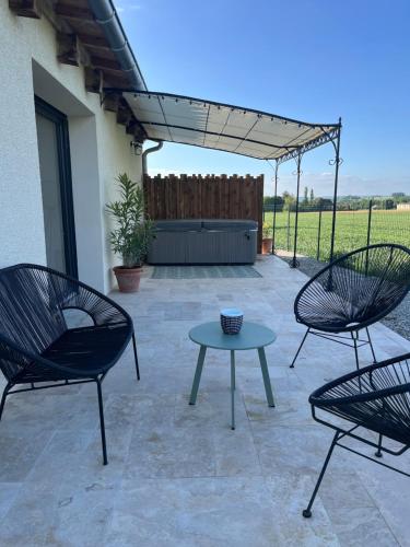 un patio avec deux chaises et une table et une clôture dans l'établissement La placette, à Marches
