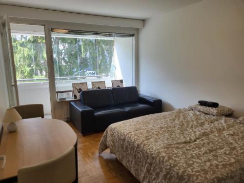 a bedroom with a bed and a couch and a table at Convenient Stay Helsinki in Helsinki