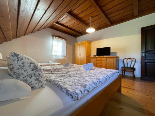 a bedroom with a large bed with a wooden ceiling at House Donačka Gora in Rogatec