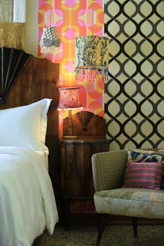 a bedroom with a bed and a chair and a lamp at Novecento Boutique Hotel in Venice