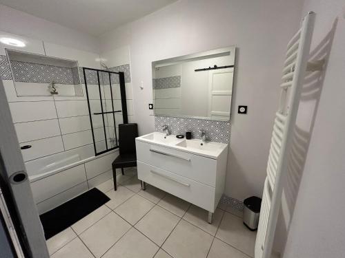 a white bathroom with a sink and a mirror at Sereine d'Argouges in Bayeux