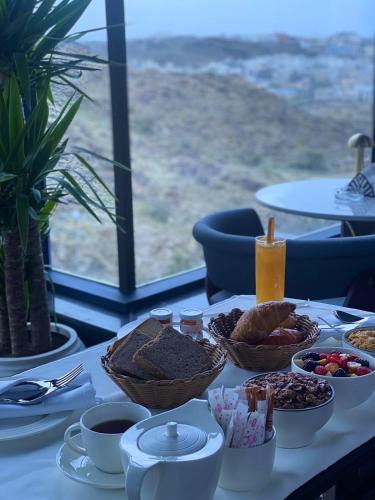 a table with a breakfast of bread and other foods at Swiss International Taif in Taif