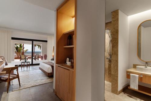 een badkamer met een wastafel en een badkamer met een slaapkamer bij The Club by Fanar in Salalah