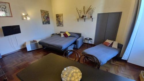 a living room with two beds and a table at Quiet in Biancamano - Casa Vacanze Roma in Rome
