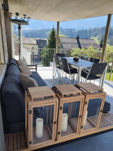 eine Terrasse mit einem Sofa, einem Tisch und Stühlen in der Unterkunft Panorama in Escholzmatt