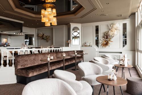 a restaurant with white chairs and tables and a bar at Hotel Beach Palace by CW Hotel Collection in Blankenberge