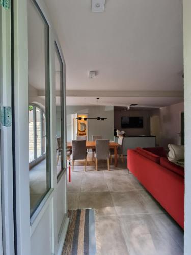 ein Wohnzimmer mit einem roten Sofa und einem Esszimmer in der Unterkunft Ferienhaus zum Wehlener Grund in Stadt Wehlen