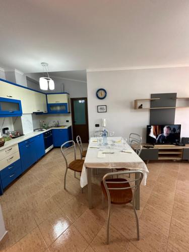 cocina con armarios azules, mesa y sillas en 1bedroom holiday apartment with amazing view Golem,Durres en Golem