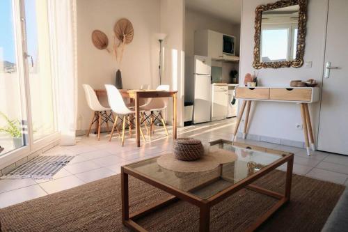 un salon avec une table et une salle à manger dans l'établissement Appartement Hyères centre avec piscine et parking privé, à Hyères