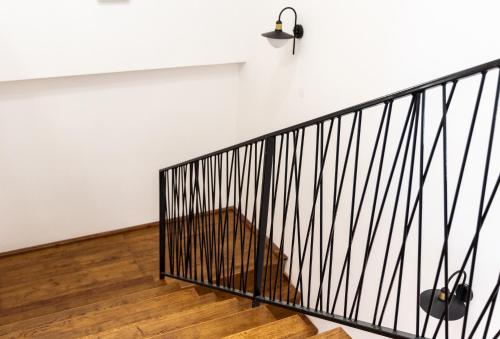 a staircase with black railings and a white wall at Pansion Mihića dvori in Babina Greda
