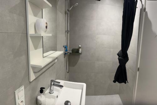 Un baño con lavabo, espejo y ducha. en Casa Lemra, en San Fulgencio
