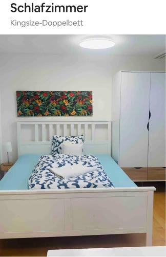 um quarto com uma cama branca e um edredão azul em 25m2 Studio with Kitchen in Zürich em Zurique