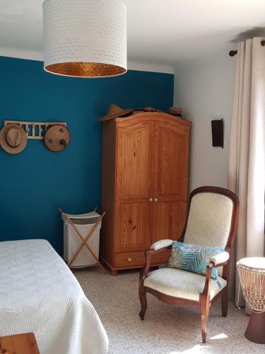 - une chambre avec un lit, une chaise et une armoire dans l'établissement La cachette, à Carcès