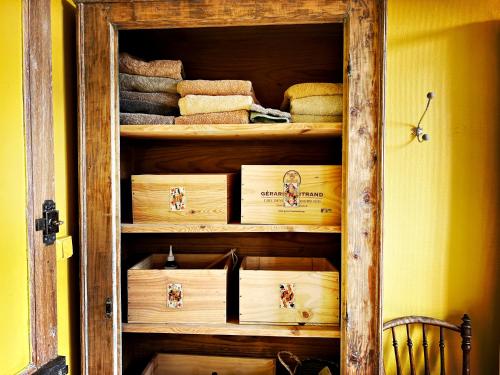 a wooden cabinet with towels in a room at Maison Beurdelaine in Avallon