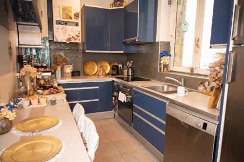 une cuisine avec des armoires bleues et un évier dans l'établissement Appartement location T3 Paris 11, à Paris