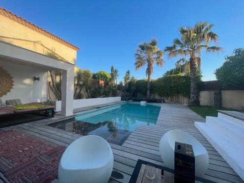 une cour avec une piscine et des palmiers dans l'établissement Can Romano, à Clapiers