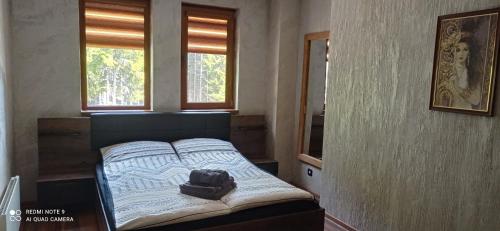 Un dormitorio con una cama con una mochila. en АПАРТАМЕНТ WISH, en Pamporovo