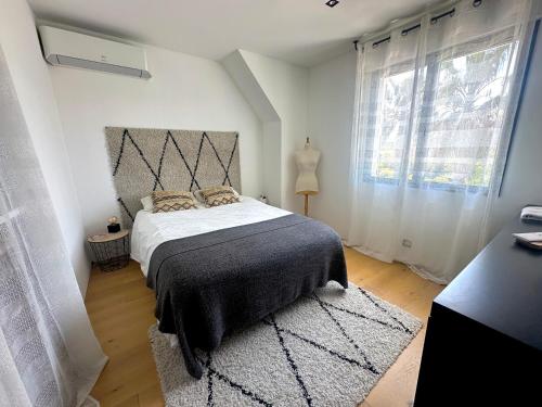 une chambre avec un lit et une grande fenêtre dans l'établissement Can Romano, à Clapiers