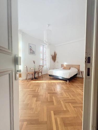 une chambre avec un lit et un parquet dans l'établissement - - Maison ŪMA - - Wifi, Netflix, Mer et Centre, à Marseille
