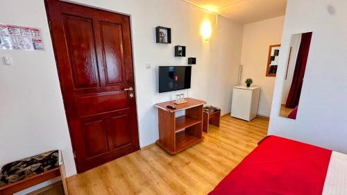 a room with a door and a small table with a television at Valea Albă View - SELF CHECK-IN in Buşteni