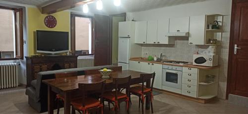 a kitchen with a wooden table and a dining room at Casa Regina in Dongo