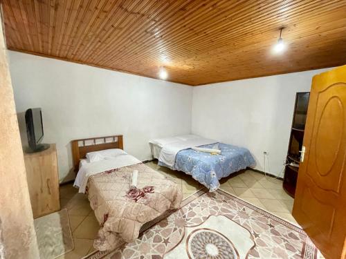 um quarto com duas camas e uma tv nele em GuestHouse Lokthi em Theth