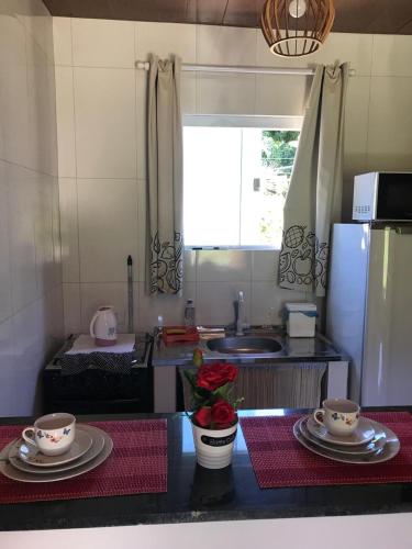 a kitchen with plates and dishes on a counter at Chalé Topázio no Recanto Diamantina entre Palmeiras e Capão in Palmeiras