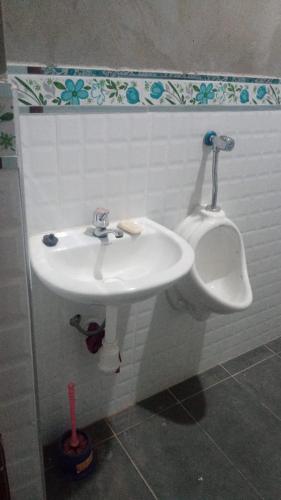 ein Badezimmer mit einem weißen Waschbecken und einem Urinal in der Unterkunft Los Tunales 