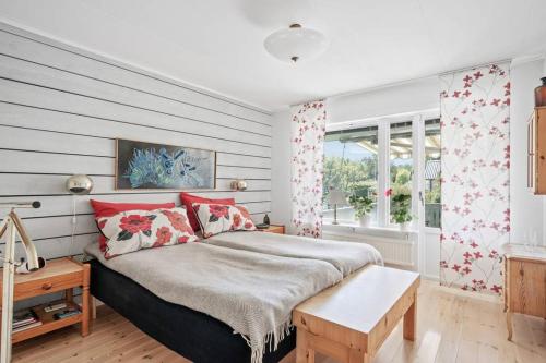 een slaapkamer met een groot bed met rode kussens bij Hagavägen 5 in Grebbestad