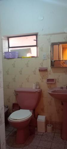 Un baño con inodoro, lavabo y ventana. en Casa cálida el hornocal, en Humahuaca