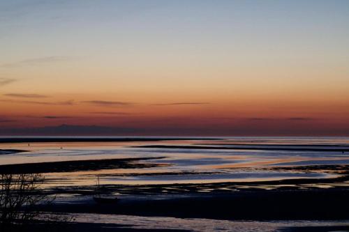 a sunset on the beach with the tide out at The Commodore Hotel in Instow