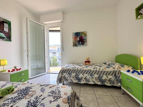 a bedroom with two beds and a teddy bear sitting on the bed at Residence Oceanico in Lignano Sabbiadoro