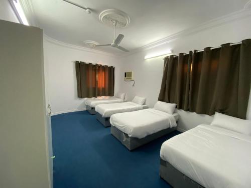 a room with three beds and a window at نسائم العنبرية in Al Madinah