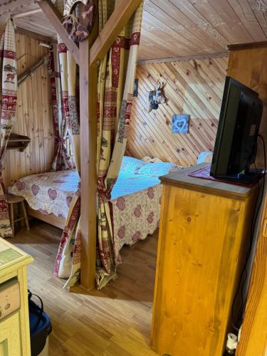 Cette chambre comprend un lit et une télévision. dans l'établissement Appartement cosy a Montchavin, à La Plagne Tarentaise