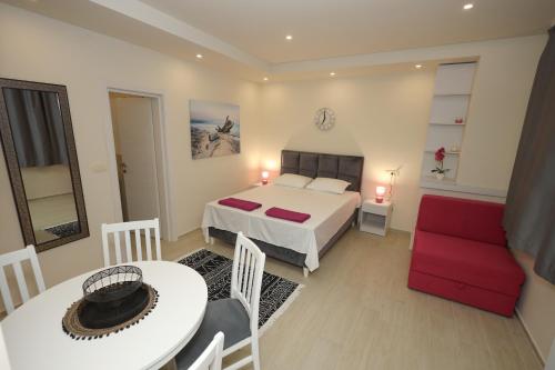 a bedroom with a bed and a table and a chair at Apartments Milanović in Herceg-Novi