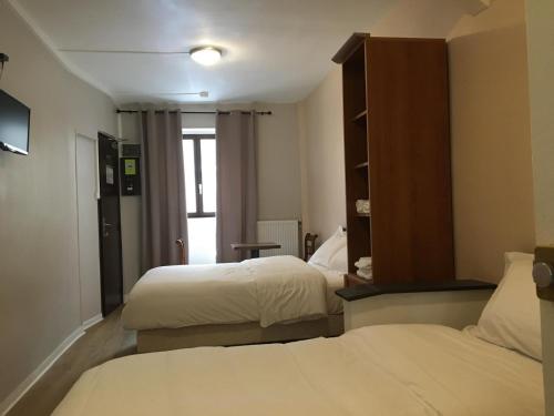 une chambre d'hôtel avec deux lits et un miroir dans l'établissement le paris saint ouen, à Paris