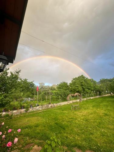 a rainbow in the sky over a field at VILA DISHA in Tirana
