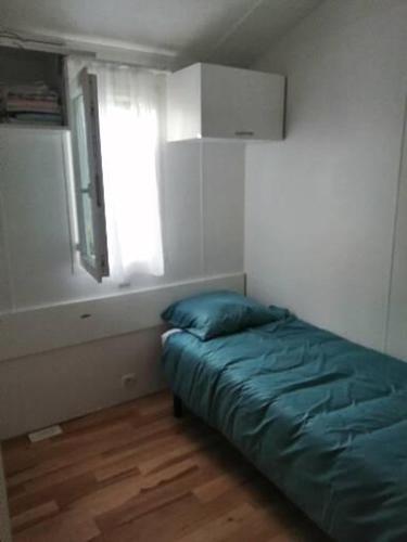 1 dormitorio con 1 cama en una habitación con ventana en Mobil home centre ville, en Pleurtuit