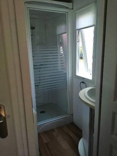 uma casa de banho com um chuveiro e um lavatório. em Mobil home centre ville em Pleurtuit
