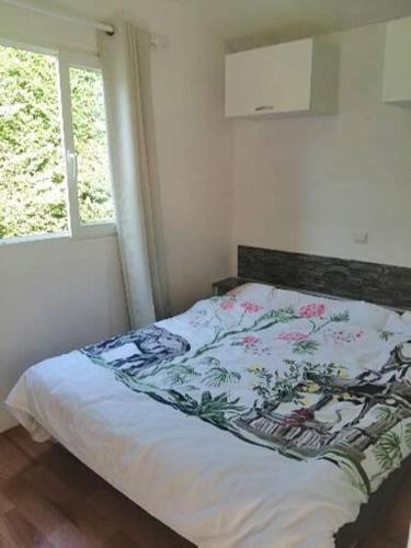 uma cama num quarto com uma janela em Mobil home centre ville em Pleurtuit