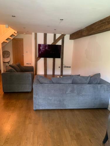 a living room with a couch and a tv at BARN: Sleeps 6, Stansted 12 mins in Hatfield Broad Oak