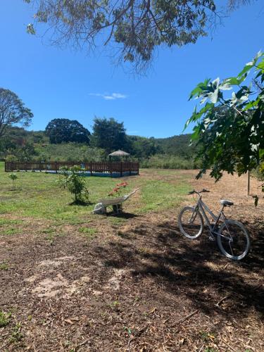un vélo garé à côté d'un banc dans un champ dans l'établissement Chalé Topázio no Recanto Diamantina entre Palmeiras e Capão, à Palmeiras