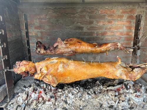 two chickens are cooking on a grill at VILA DISHA in Tirana