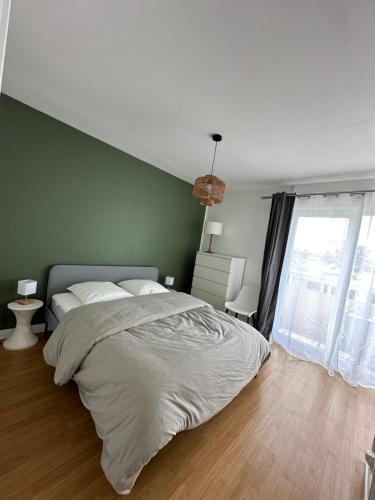 une chambre avec un grand lit et un mur végétal dans l'établissement Bel appartement - LM la Mer, à Berck-sur-Mer