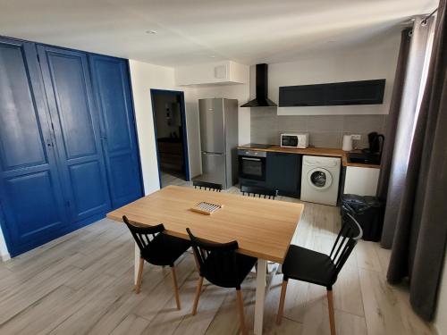 een keuken met een houten tafel en stoelen in een kamer bij centre de Thuir appart cosy in Thuir