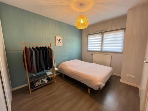 - une chambre avec un lit et un portant dans l'établissement Jolie maison de Ville au Mans, au Mans